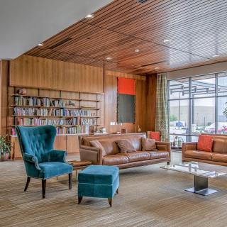 A stylish living room with modern decor featuring a wooden bookshelf and comfortable seating.