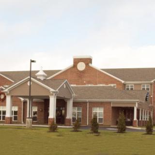 A large brick building with a clock tower and well-maintained grounds.