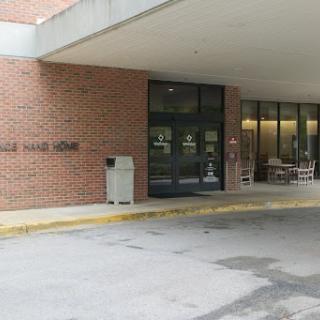 Entrance of a modern brick building featuring large glass windows.