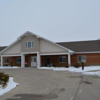 A residential building with a snowy driveway in the winter.