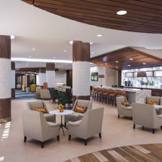 A stylish hotel lobby featuring a cozy seating area and a modern bar, designed for relaxation and socializing.
