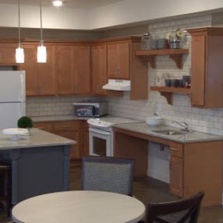 A modern kitchen showcasing wooden cabinetry, white appliances, and a cozy dining space.