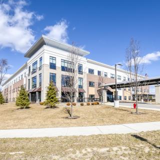 A modern commercial office building on a sunny day with a clear blue sky.