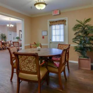 A cozy dining area with wooden table and chairs, complemented by warm lighting and indoor plants.