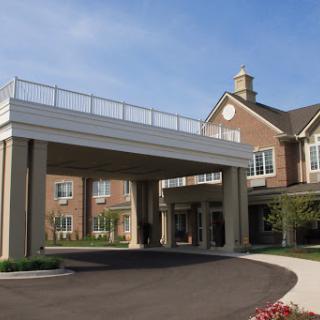 A well-designed entrance to a residential or commercial building with a grand overhang and landscaped surroundings.