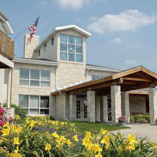 A modern house with a welcoming garden featuring yellow flowers and an American flag waving in the breeze.