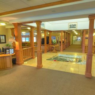 A spacious hotel lobby with wooden columns and warm lighting.
