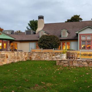 A charming house with stone walls and a well-maintained garden.