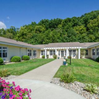 A peaceful building surrounded by lush greenery and a well-maintained garden.