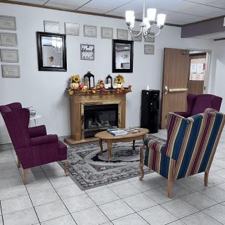 A cozy waiting room with colorful chairs and a decorative fireplace.