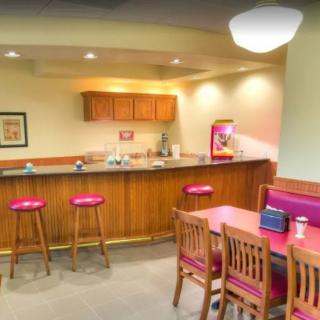 A cozy kitchen dining area with barstools and a wooden table.