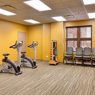 A small gym space with exercise bikes and weights.