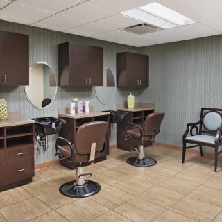 A modern hair salon interior with swivel chairs and mirrors.