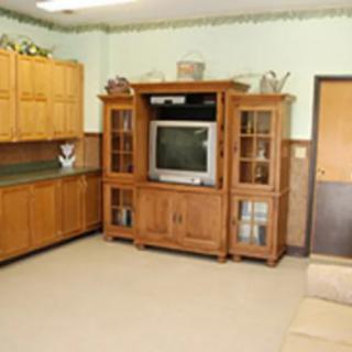 A cozy living room with a wooden entertainment center and television.