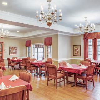 An elegant dining room with chandeliers and red-accented decor.