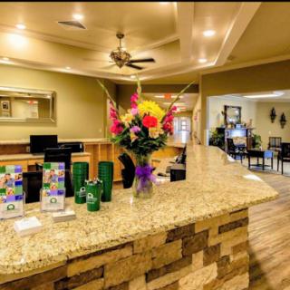 A warm and inviting reception area featuring a beautifully arranged flower display and a granite counter.