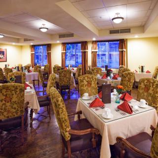 An elegant restaurant dining room with neatly arranged tables and chairs.