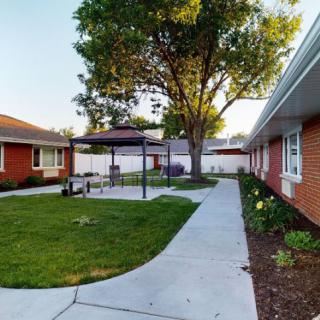 A peaceful courtyard with a gazebo, surrounded by brick buildings and well-maintained landscaping.