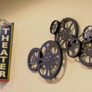 A wall decorated with film reels and a theater sign, evoking a cinematic atmosphere.