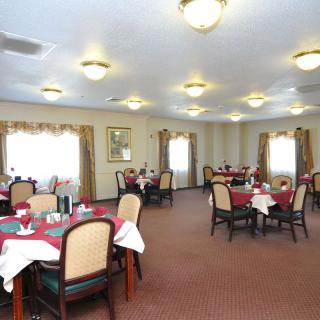 An elegantly set dining room with tables and chairs arranged for guests.