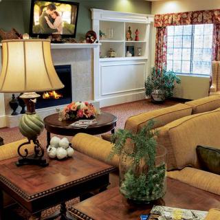 A cozy and well-decorated living room with a television, comfortable sofas, and elegant lighting.