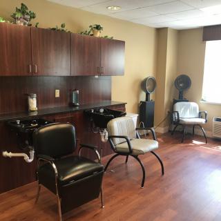 A cozy salon interior with hair styling chairs and dryers.