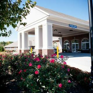 A view of a bank building with blooming flowers in the foreground on a sunny day.