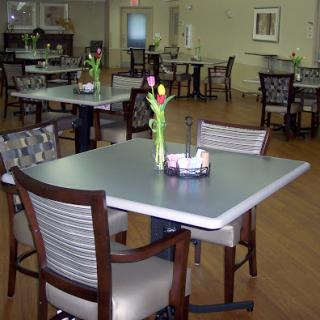 A cozy dining area featuring tables set with flowers, creating a welcoming atmosphere.