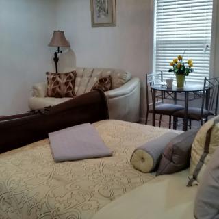 Cozy bedroom with a comfortable bed, seating area, and a small dining table adorned with flowers.