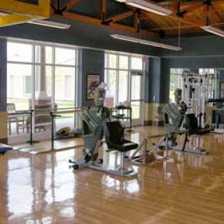A view of a spacious gym equipped with various exercise machines.