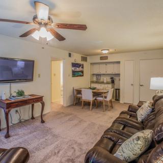 A cozy living room with a comfortable sofa, TV, and dining area.