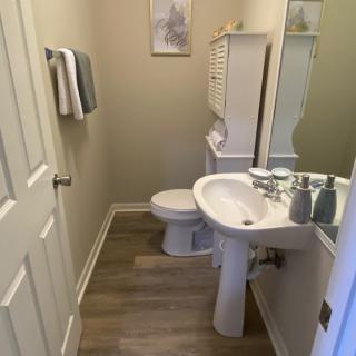 A neatly organized bathroom with a pedestal sink and mirror.