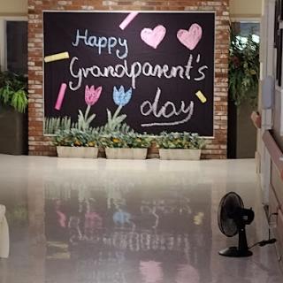 A vibrant chalkboard greeting celebrating Grandparents Day, adorned with colorful drawings and a touch of greenery.