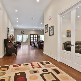 Spacious hallway leading into a living area with hardwood floors and cozy furnishings.