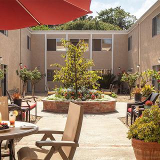 A peaceful courtyard with seating and a central garden feature.