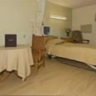 A hospital room featuring a bed, a table, and chairs in a medical setting.
