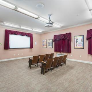 A cozy movie theater-style presentation room, equipped with comfortable seating and a projector for screenings.