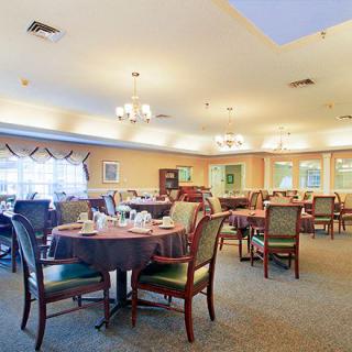 A spacious and well-lit dining room with neatly arranged tables and chairs.