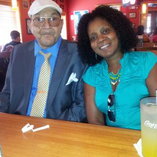 Two people sitting at a restaurant table, smiling.