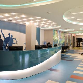 A bright and modern office reception area featuring a sleek design and colorful flooring.