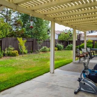 A well-maintained backyard with a patio, pergola, and garden.