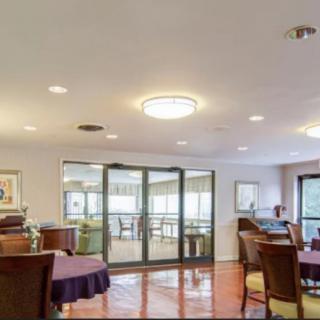A modern dining area with tables and chairs, featuring contemporary lighting.