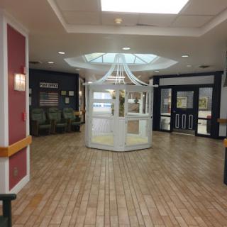 A spacious lobby area with modern decor, featuring a central kiosk and ample seating.