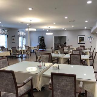 A well-lit dining room with neatly arranged tables and chairs.