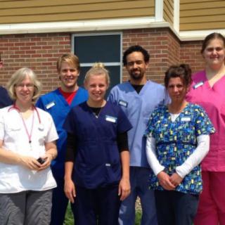 A group of medical staff standing together outside a brick building.