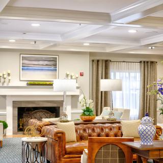 A well-decorated living room featuring a leather sofa, fireplace, and elegant lighting.