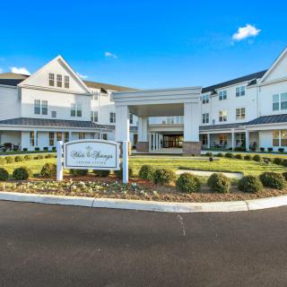 A modern, multi-story building with well-maintained landscaping and a prominent entrance sign.