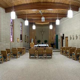 Interior view of a chapel with seating and an altar.
