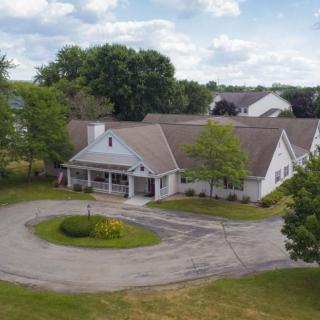 Aerial view of a residential building with a circular driveway and surrounding trees.