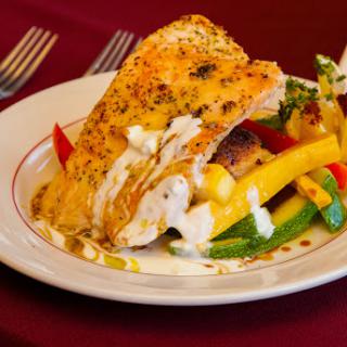 A beautifully plated grilled salmon served with a colorful array of sauted vegetables.